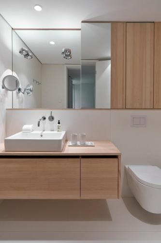 a bathroom with a sink and a toilet and a mirror at Inselhouse in Norderney