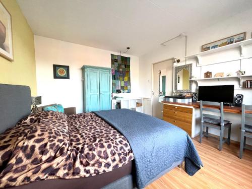 a bedroom with a leopard print bed and a desk at City room in Alkmaar