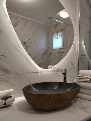 a bathroom with a stone sink and a mirror at Tharroe of Mykonos Boutique Hotel in Mýkonos City