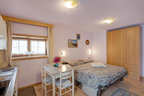 a small bedroom with a bed and a table at Orsa Minore in Livigno
