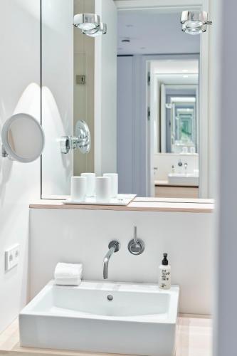 a white bathroom with a sink and a mirror at Inselhouse in Norderney