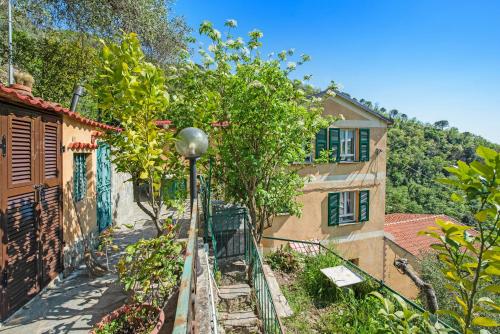 a house with a fence in front of a tree at Tavernetta in campagna in Zoagli