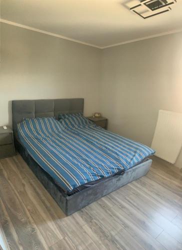 a bedroom with a bed with a blue comforter at Klimatyzowany apartament z miejscem garażowym in Gorzów Wielkopolski