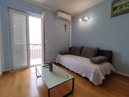 a bedroom with a bed and a table and a window at Apartment Angela in Dubrovnik
