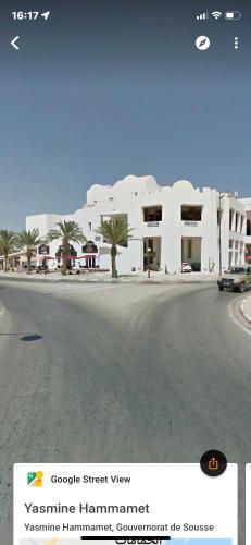 a street view of a white apartment building at Résidence aladin in Hammamet Sud
