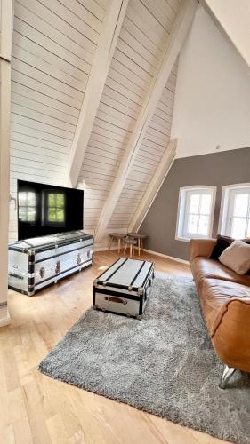a living room with a couch and a tv at Gemütliche Maisonettewohnung mit Dachterrasse am Schloß in Oldenburg