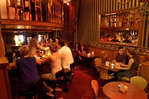 a group of people sitting at tables in a restaurant at Rembrandtplein Hotel in Amsterdam