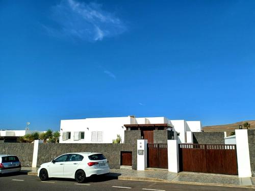 a white car parked in front of a building at VILLA LANZAROTE in Puerto Calero