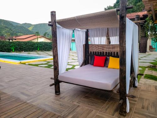 a bed in a hammock next to a pool at Pousada Dom Dimitri in Lumiar