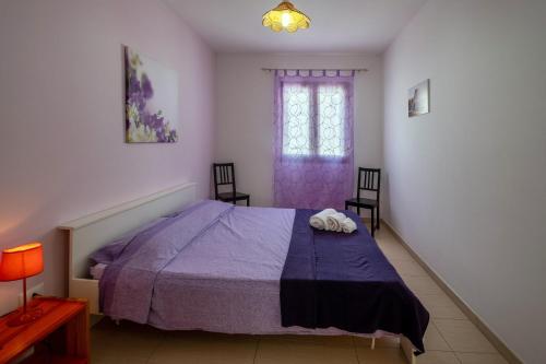 a bedroom with a purple bed and two chairs at Staiulo - Primo Piano - La Plumeria in Leuca