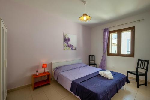 a bedroom with a bed and a window and a chair at Staiulo - Primo Piano - La Plumeria in Leuca