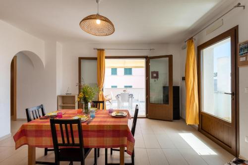 a dining room with a table and chairs and a window at Staiulo - Primo Piano - La Plumeria in Leuca