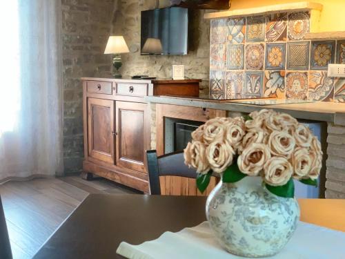 a vase with roses in it sitting on a table at Agriturismo Fonte Rosa in Fiastra