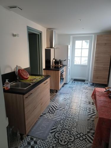 eine Küche mit einer Spüle und einer Arbeitsplatte in der Unterkunft Maison de village entre estuaire et océan in Saint-Yzans-de-Médoc