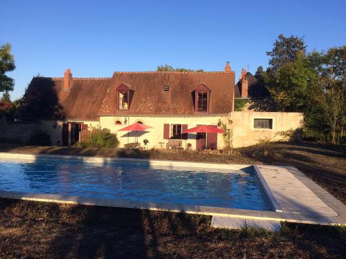 a house with a swimming pool in front of a house at Cottage du vigneron in Vernou-sur-Brenne