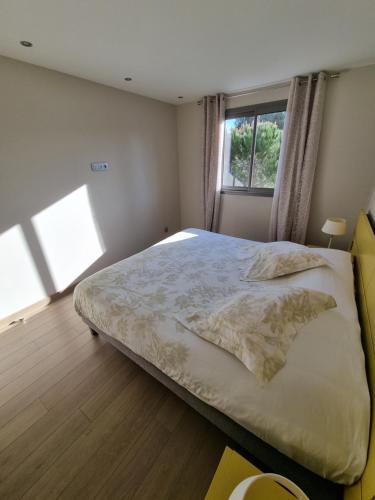 um quarto com uma cama grande e uma janela em Résidence Costa Nera Santa Giulia em Porto-Vecchio