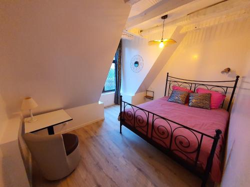 una camera con letto con lenzuola rosa e scrivania di Appartement de 8 chambres avec piscine partagee jardin amenage et wifi a Vernou sur Brenne a Vernou-sur-Brenne