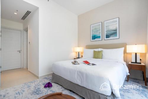 a bedroom with a large white bed and two lamps at Dream Inn Apartments - Address Beach Residence Fujairah in Fujairah