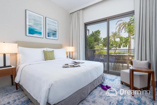 a bedroom with a large bed and a large window at Dream Inn Apartments - Address Beach Residence Fujairah in Fujairah