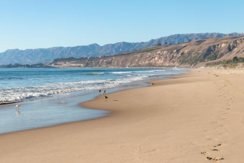 a group of people walking on a beach at Breakers Way Dream in Carpinteria
