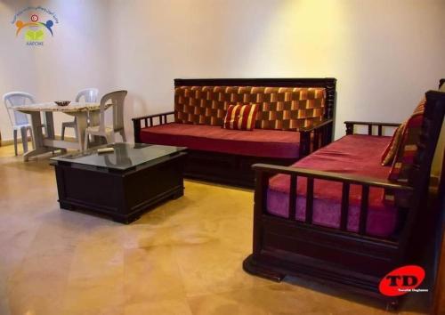 un soggiorno con 2 letti e un tavolo di Résidence aladin a Hammamet Sud