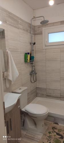 a bathroom with a toilet and a tub and a sink at Classic House in Lefkímmi