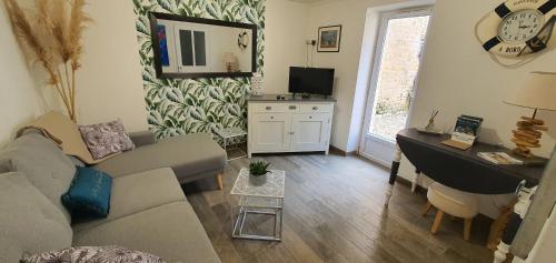 un salon avec un canapé et un bureau dans l'établissement Beach House & Patio by Melrose, à Arromanches-les-Bains