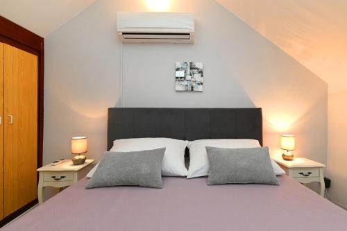 una camera da letto con un grande letto con due lampade su due tavoli di Oleander Apartments Split a Spalato (Split)