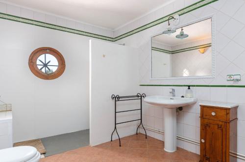 y baño con lavabo, espejo y aseo. en YourHouse Son Morey, villa with private pool, family-friendly, en Mora
