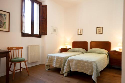sypialnia z 2 łóżkami, krzesłem i oknem w obiekcie Roommo Viuzzo delle Canne we Florencji
