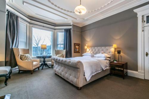 a bedroom with a bed and a chair and a window at Ryan Mansion in St. John's