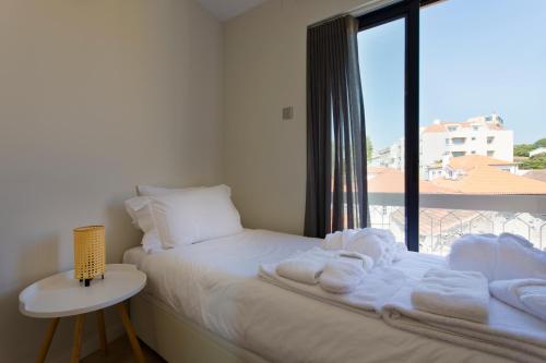 um quarto com uma cama e uma janela com toalhas em Ocean Scene 2 bed Apt no Porto