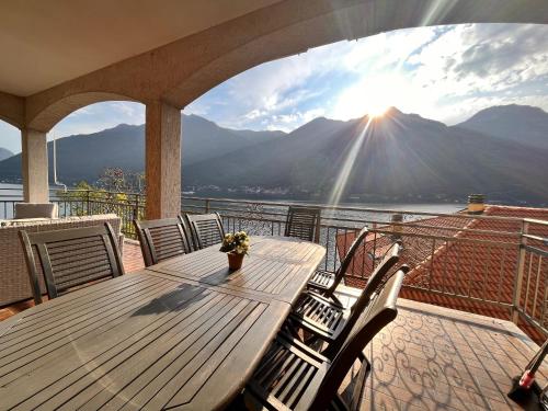 a wooden table on a balcony with a view of a mountain at Villa Rosina Veranda in Nesso