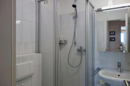 een badkamer met een douche en een wastafel bij Residenz 18 in Duhnen