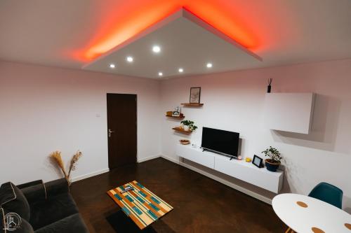 a living room with a couch and a tv at ZAZA Apartament - central area, with balcony in Târgu Jiu