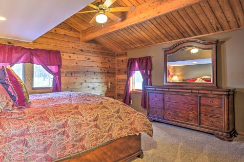 a bedroom with a bed and a dresser with a mirror at Lodge with Indoor Pool, Along Devils Lake Park in Merrimac