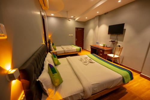 a hotel room with two beds and a desk at HOTEL MITTAL GARDEN in Siliguri