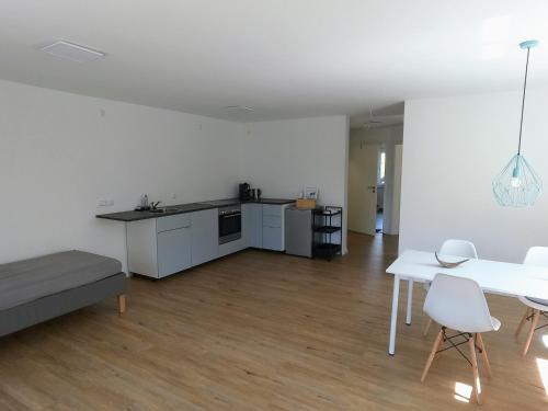 a kitchen and living room with a table and chairs at großzügiges, helles und modernes Hiloa-Apartment in Hochdorf