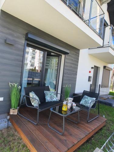a deck with two chairs and a table at Horizon Park Carlo Rossi in Dziwnówek