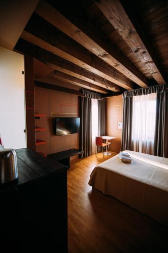 a bedroom with a bed and a desk in it at Ristolocanda Grani Di Pepe in Flaibano