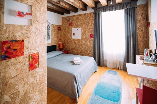 a bedroom with a bed and a large window at Ristolocanda Grani Di Pepe in Flaibano