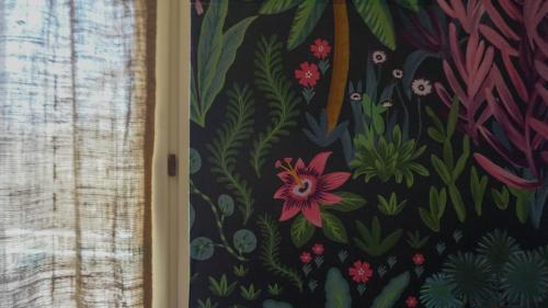 a painting of flowers on a wall next to a window at B&B La Buonora in Sinio