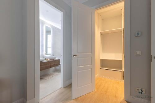 una puerta abierta a un baño con lavabo en Living4Malaga Echegaray Grand Luxe, en Málaga