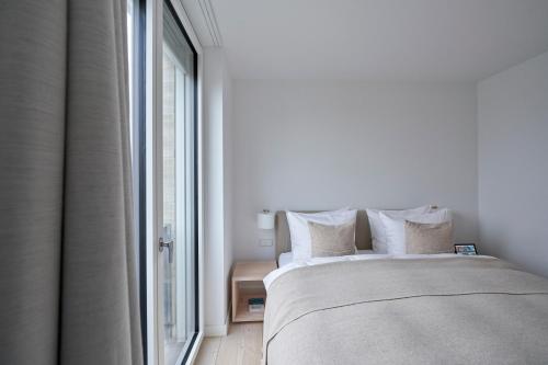 a bedroom with a bed and a large window at Inselhouse in Norderney