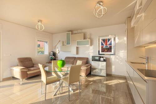 Una cocina y una sala de estar con una mesa de cristal y sillas. en Il Marino - Santo Stefano, en Santo Stefano al Mare