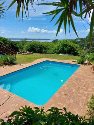a blue swimming pool with a view of the ocean at The Lake House in Hluhluwe