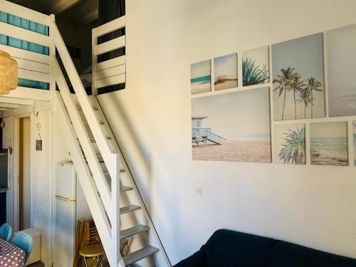 a staircase in a room with pictures on the wall at T2 bis terrasse PORT LEUCATE in Port Leucate