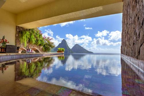 a pool with a view of the water and mountains at Jade Mountain in Soufrière