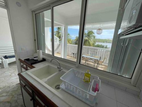 uma cozinha com um lavatório e vista para o oceano em Appart adorable proche de la baie orientale, Idolem résidence unité 2 - 57 Rue du Mont Vernon 1 em Cul de Sac