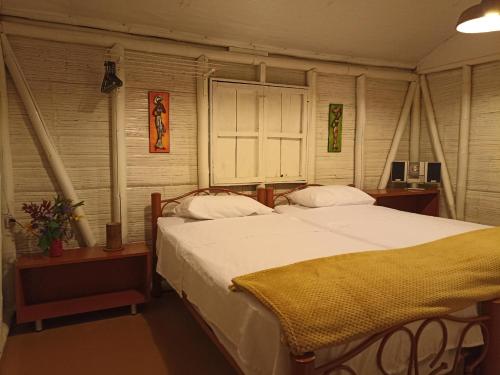 a bedroom with a large bed with white sheets at Casa Rustica La Bella Filandia in Filandia